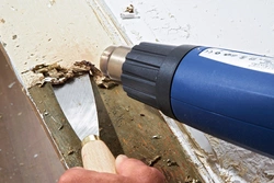 Verwenden Sie eine Heißluftpistole um getrocknete Acrylfarbenflecken von der Holzoberfläche zu entfernen